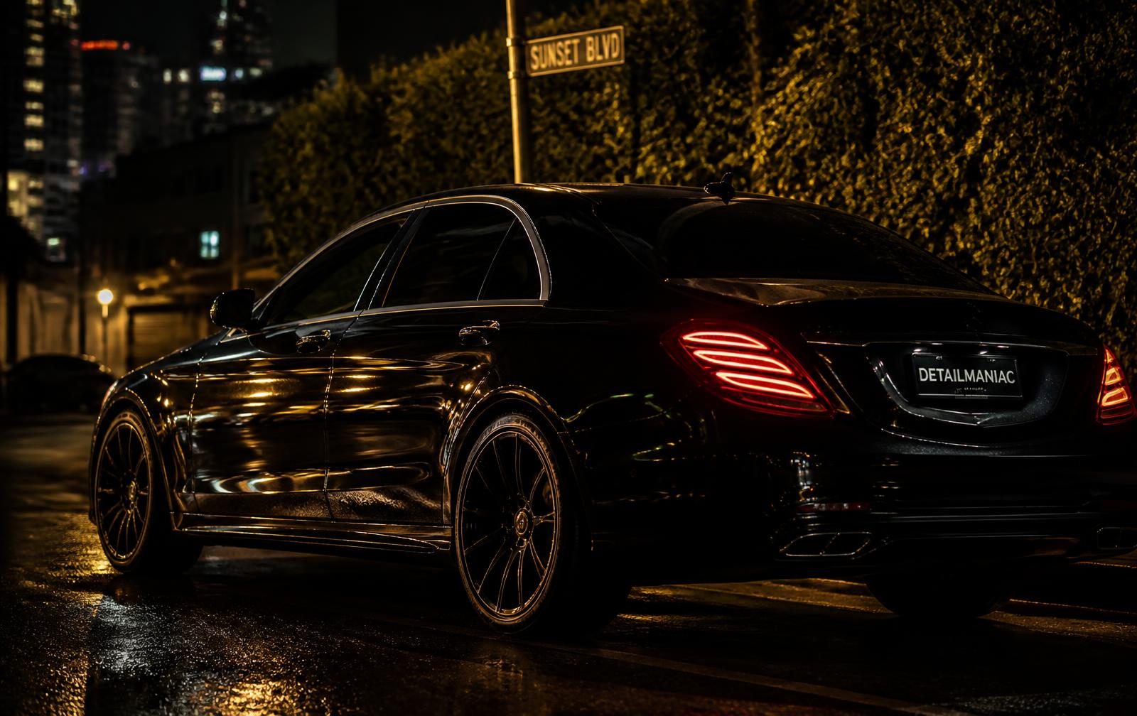Freshly detailed black luxury sedan on a Los Angeles street at night